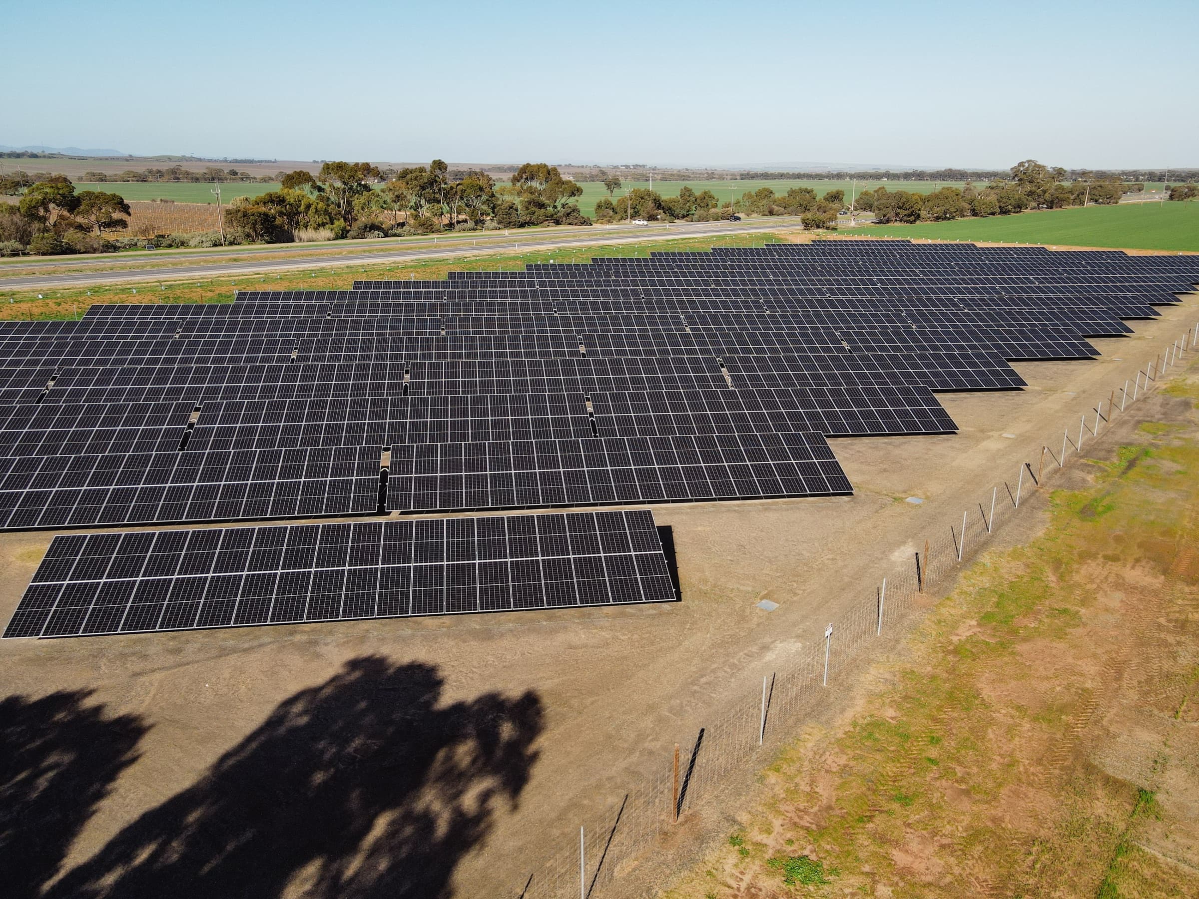 Close aerial view of the ground-mounted solar array rows